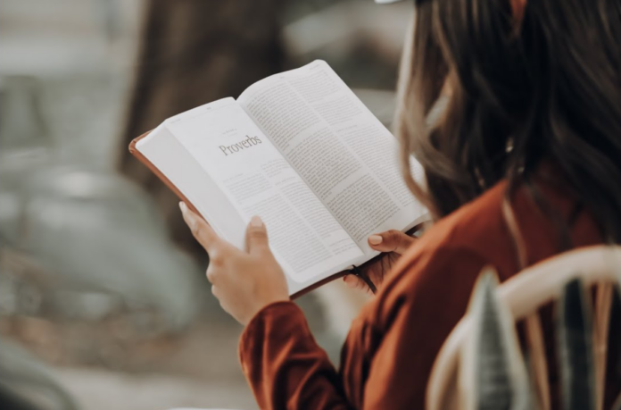 Woman reading a book. Benefits of book reading on the person's self-assurance.