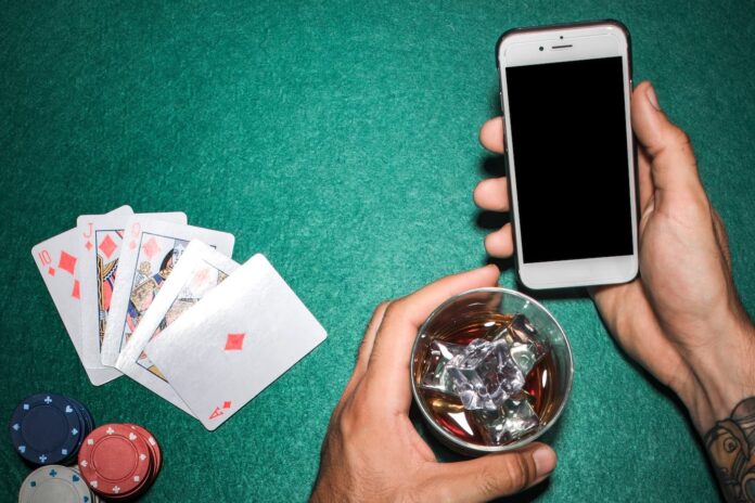 Gambling, drinks and phone. Depiction of online gambling and mobile gambling